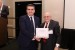 Dr. Nagib Callaos, General Chair, giving Mr. Ako K. Omer the best paper award certificate of the session "Applications of Informatics and Cybernetics in Science and Engineering." The title of the awarded paper is "Corrosion Simulation of High Stress Three Body Abrasion."